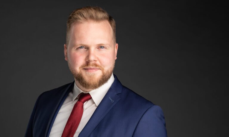 Zakelijk portret van Philip De Rudder in maatpak met das